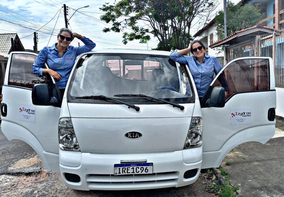 Engenheiras da Izydros Engenharia ao lado do veículo de equipe da empresa